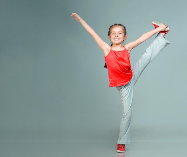 Kleines Mädchen macht Gymnastikübung im Studio