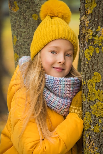 Kleines Mädchen mit blonden Haaren im Herbstpark