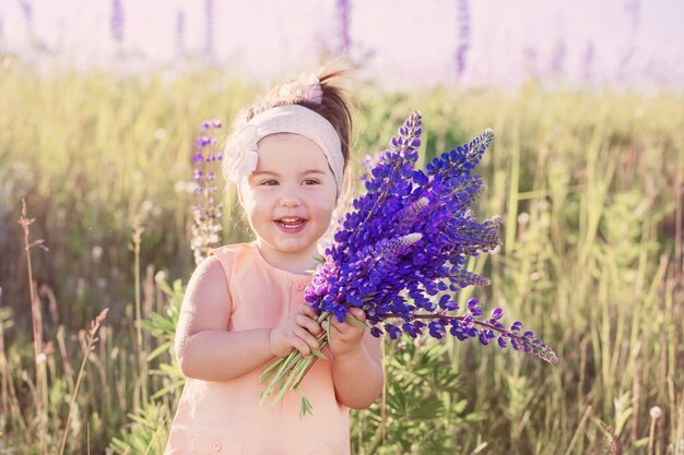 Kleines Mädchen mit Blumen im Freien