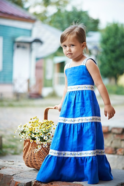 Kleines Mädchen mit Blumen im Korb