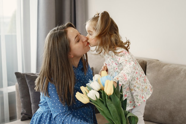 Kleines Mädchen mit Blumen. Mama ist schwanger. Grüße für Mama.