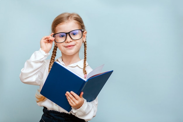 Kleines Mädchen mit Brille, die ein Buch hält