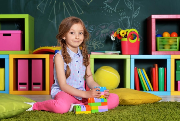 Kleines Mädchen mit bunten Plastikblöcken