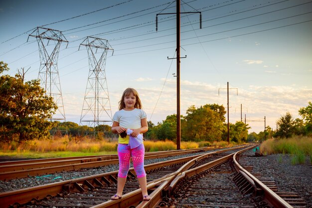 Kleines Mädchen mit der Eisenbahn. in der Nähe von Gleisen