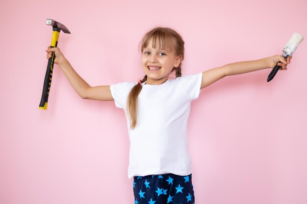 Kleines Mädchen mit einem Hammer macht Reparaturen im Kinderzimmer