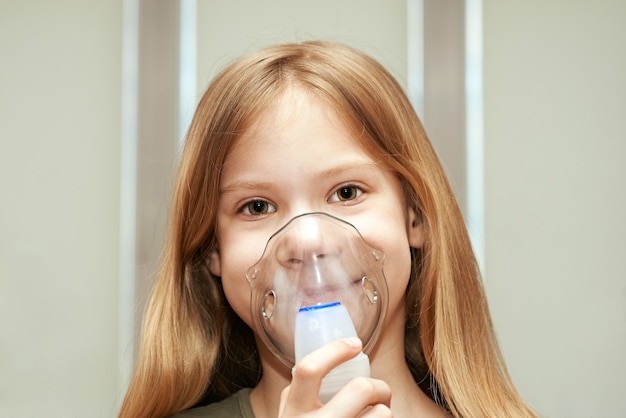 Kleines Mädchen mit einem Inhalator drinnen