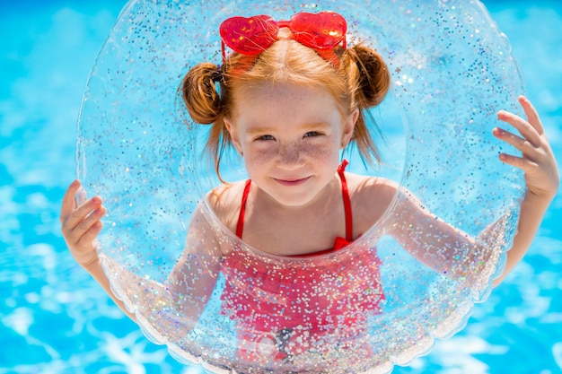 kleines Mädchen mit einem Schwimmkreis im Pool