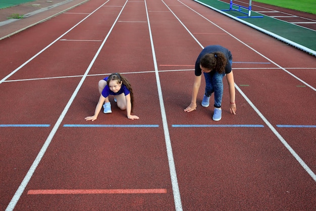 Kleines Mädchen mit einem Trainer im Stadion