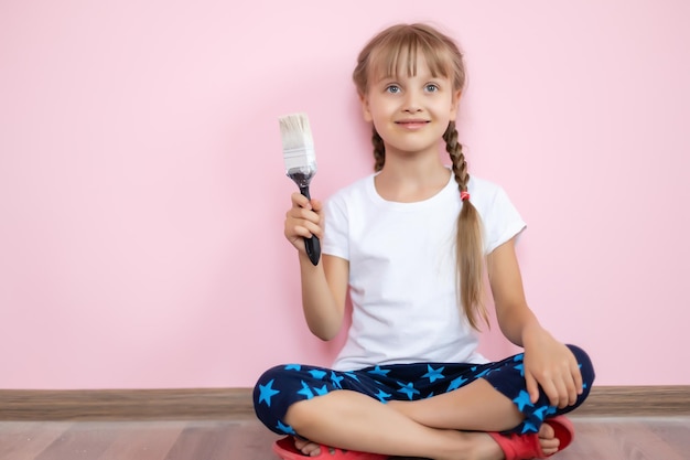 Kleines Mädchen mit einer Bürste macht Reparaturen im Kinderzimmer