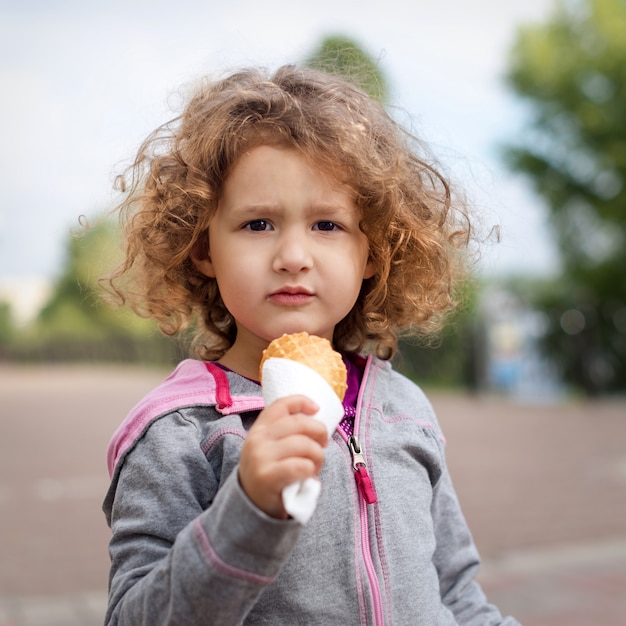 Foto kleines mädchen mit eis im park