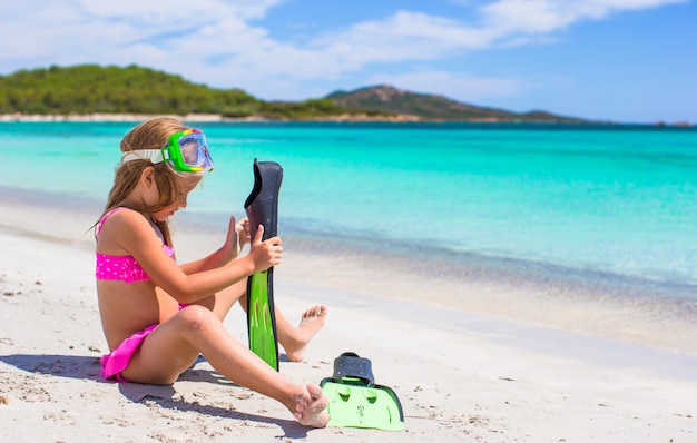 Kleines Mädchen mit Flossen und Brille zum Schnorcheln am Strand