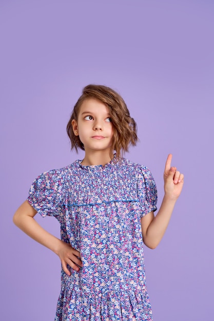 Kleines Mädchen mit lila Kleid nach oben auf lila Hintergrund
