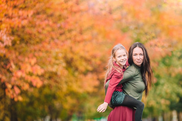 Kleines Mädchen mit Mutter draußen im Park am Herbsttag