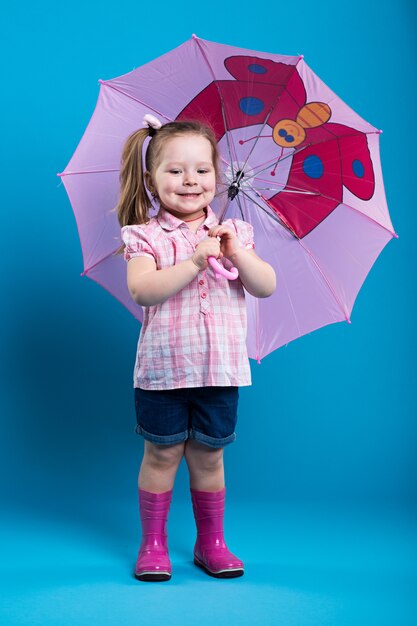 Foto kleines mädchen mit rosafarbenem regenschirm