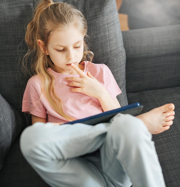 Kleines Mädchen mit Tablet zu Hause