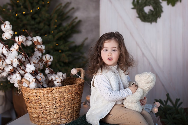 Kleines Mädchen mit Teddybär an Weihnachten