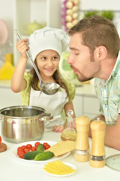 Kleines Mädchen mit Vater in der Küche, Suppe essend