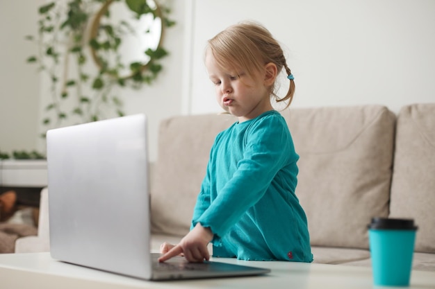 Kleines Mädchen nutzt einen Laptop-Video-Chat, um zu kommunizieren, wie das Kind zu Hause online lernt