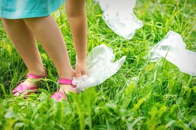 Kleines Mädchen reinigt Plastiktüten