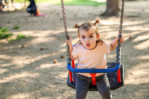 Kleines Mädchen sitzt auf der Schaukel im Park