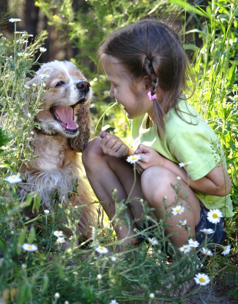 Foto kleines mädchen sitzt seite an seite mit ihrem hund