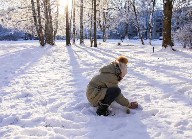 Kleines Mädchen spielt im Winterpark