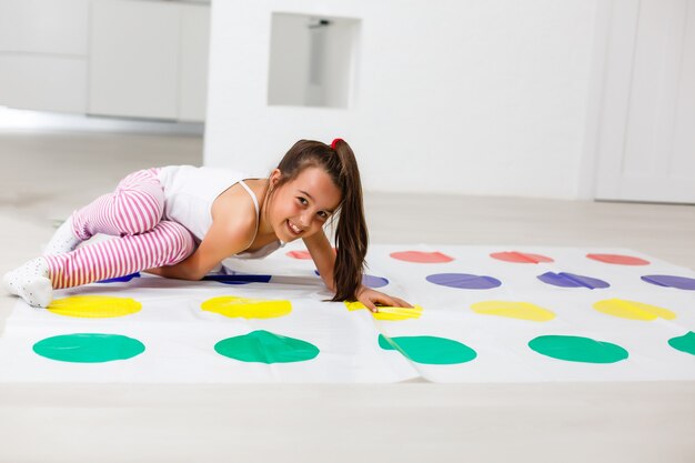 kleines Mädchen spielt Twister zu Hause