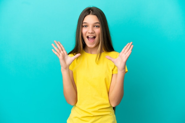 Kleines Mädchen über isoliertem blauem Hintergrund mit Überraschungsgesichtsausdruck