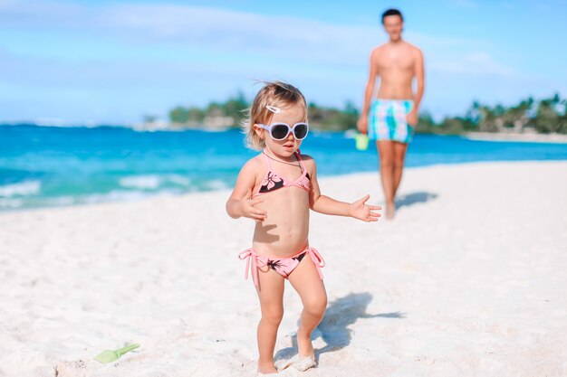 Kleines Mädchen und glücklicher Vater, der Spaß während des Strandurlaubs hat