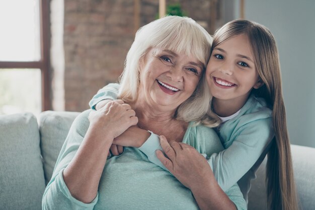 Kleines Mädchen und Großmutter sitzen auf der Couch