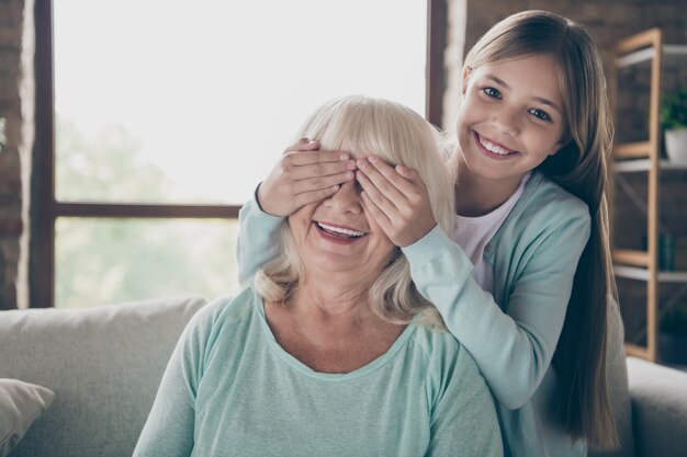 Kleines Mädchen und Großmutter sitzen auf der Couch