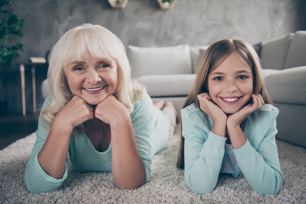 Kleines Mädchen und Großmutter sitzen auf der Couch