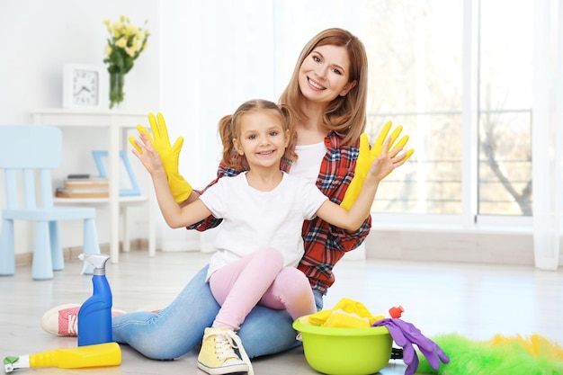 Kleines Mädchen und ihre Mutter mit Reinigungsmitteln zu Hause