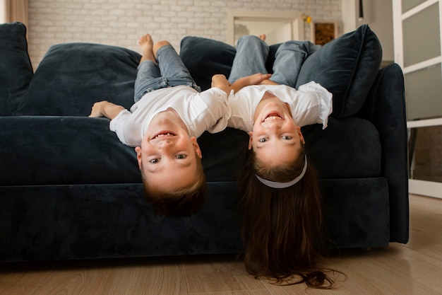 Foto kleines mädchen und junge bleiben mit ihren köpfen auf dem sofa