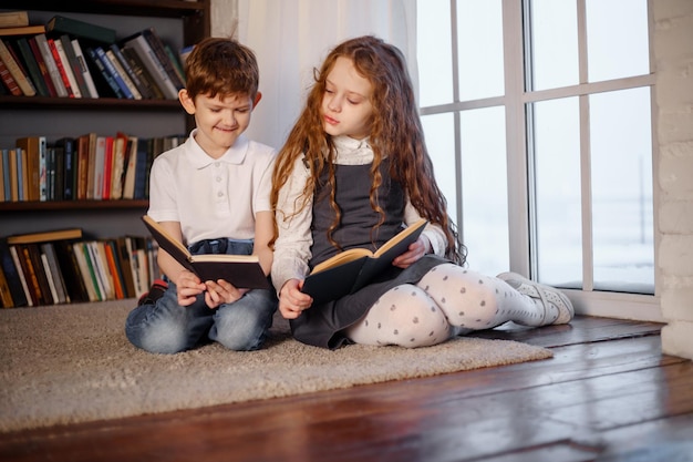 Kleines Mädchen und Junge, die das Buch lesen