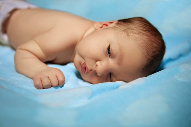 kleines neugeborenes baby auf einer blauen decke