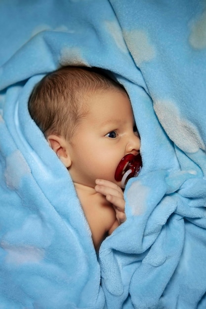 kleines neugeborenes baby auf einer blauen decke