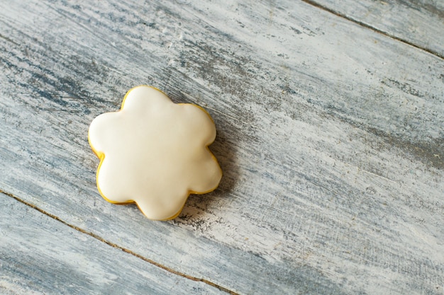 Foto kleines plätzchen in form einer blume. biskuit mit weißer glasur. hausgemachtes dessert für ein kind. wenig kalorien.