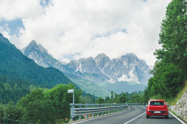 Kleines rotes Auto auf der Straße durch die Berge