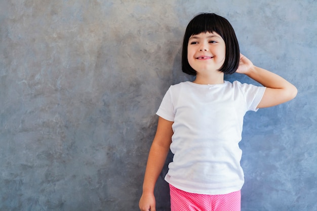 Kleines schwarzhaariges Mädchen an der Wand