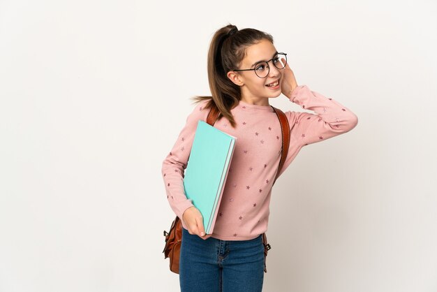 Kleines Studentenmädchen über isolierter Wand, die etwas hört, indem man Hand auf das Ohr legt