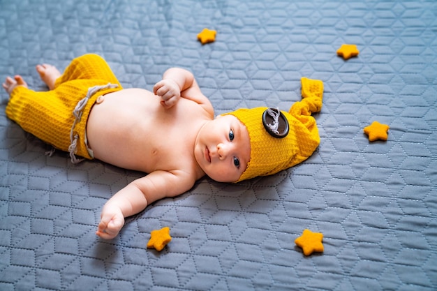 Kleines süßes Baby im Kostüm Lustiges Kind mit Hut mit dunklem Hintergrund