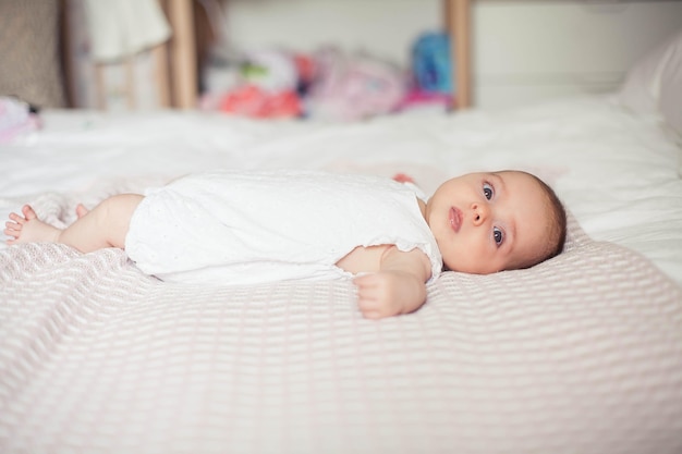 Kleines süßes Mädchen, das auf dem Bett liegt