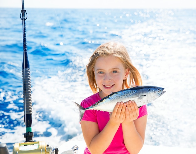 Kleines thunfisch des blonden kindermädchen-fischen-thunfischs glücklich mit fang