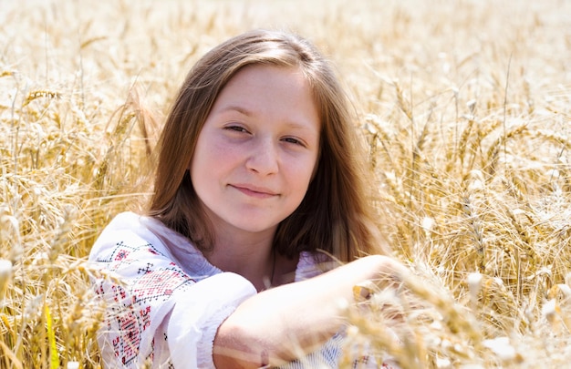 Kleines ukrainisches lächelndes Mädchen in einem Weizenfeld