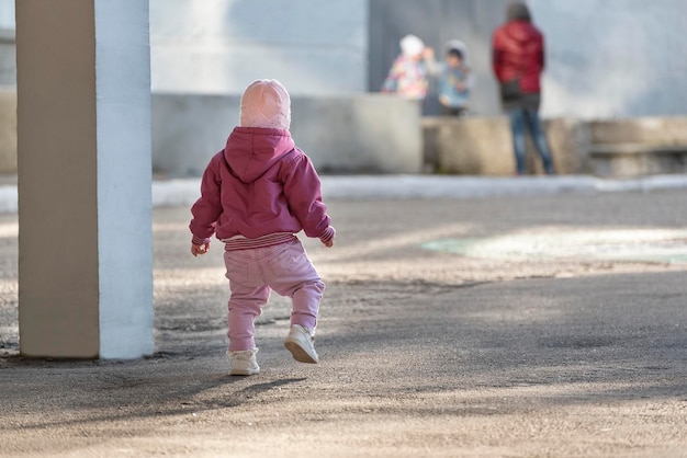 Kleinkind läuft zu den Kindern Kleines Mädchen zu Fuß auf der Straße Betondschungel und Kinder