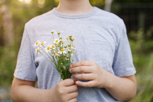 Kleinkind mit Gänseblümchenblume in der Wiese.