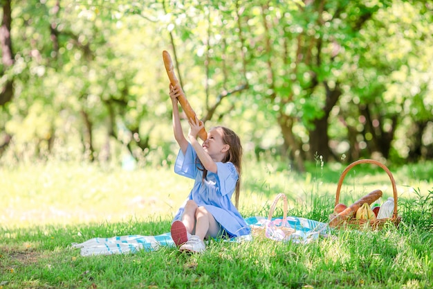 Kleinkind mit großem Brot auf Picknick im Park