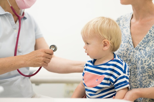 Kleinkind wird von seinem Kinderarzt während einer Standarduntersuchung untersucht