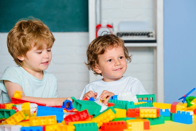 Kleinkinder spielen mit Blöcken, Zügen und Autos. Lernspielzeug für Vorschul- und Kindergartenkinder.